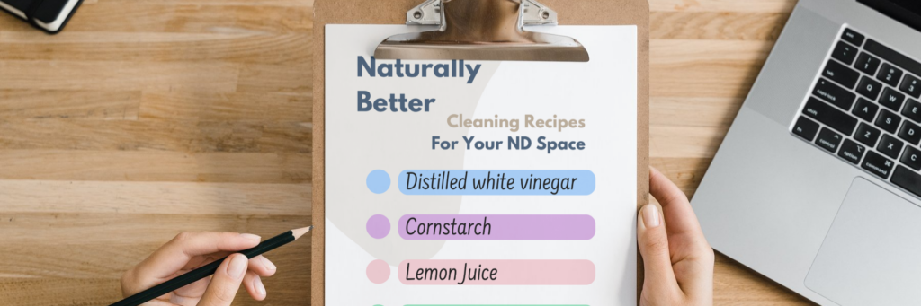 Image showing a desk with a laptop and a pair of hands holding a colourful to-do-list on a clipboard. The list is title 'Naturally Better - Cleaning Recipes for Your ND Space', with the following list of items: Distilled white vinegar, Cornstarch, Lemon Juice, Coconut oil, Rubbing Alcohol.